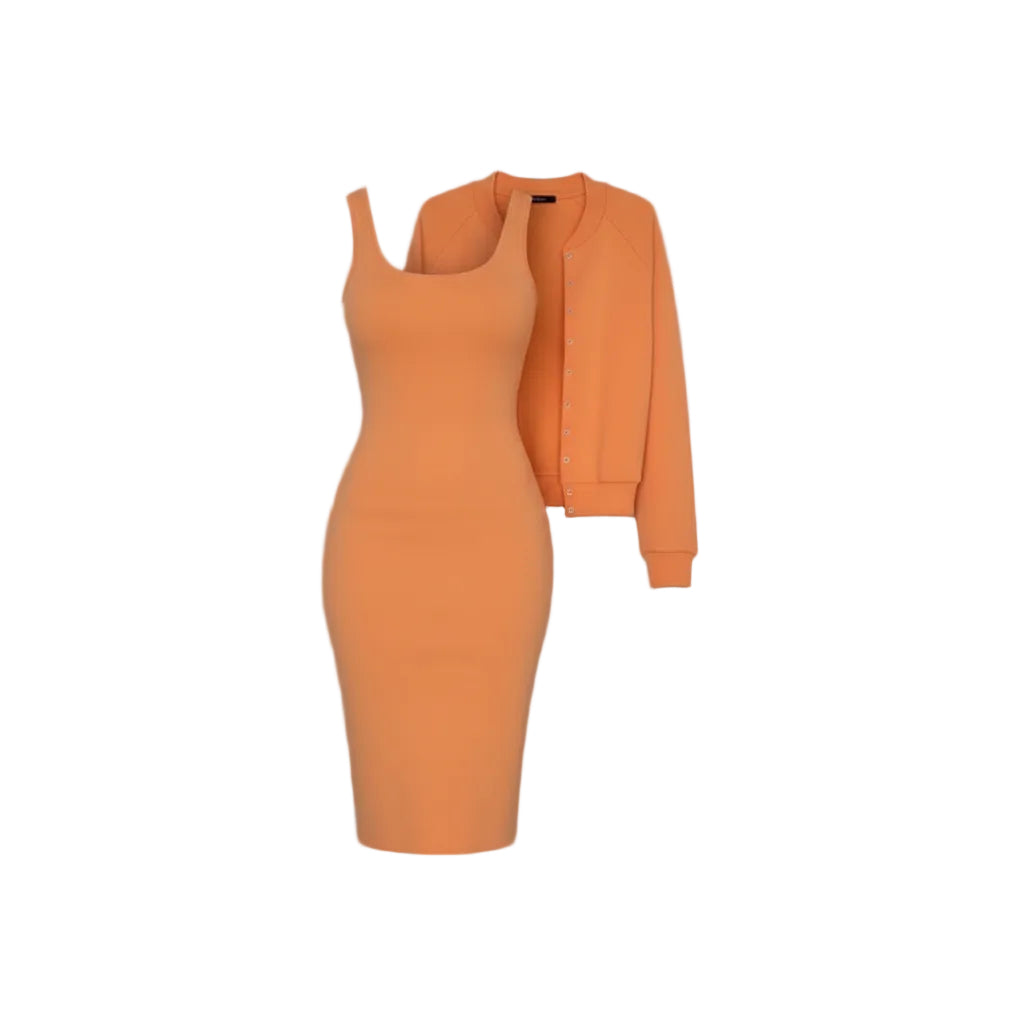 Person wearing an orange outfit with a jacket against a white wall.