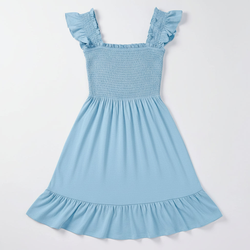 Woman wearing a light blue dress with ruffled sleeves against a plain background
