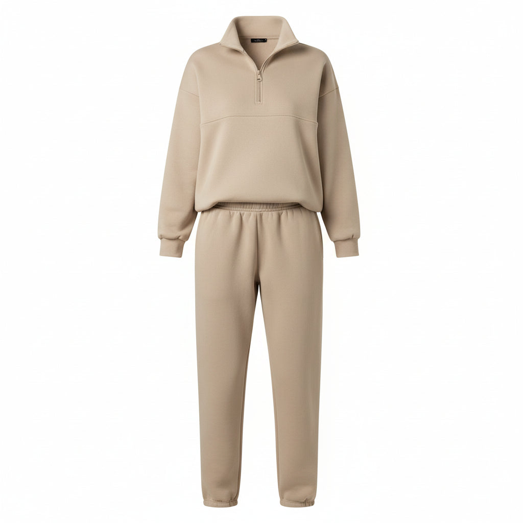 Person wearing a beige tracksuit standing in front of a glass door.
