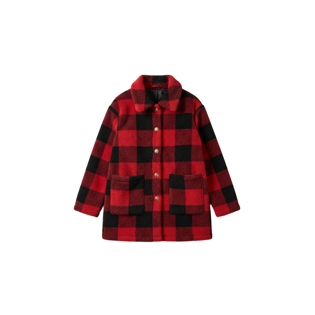 Woman wearing a red and black checkered coat on a city street.