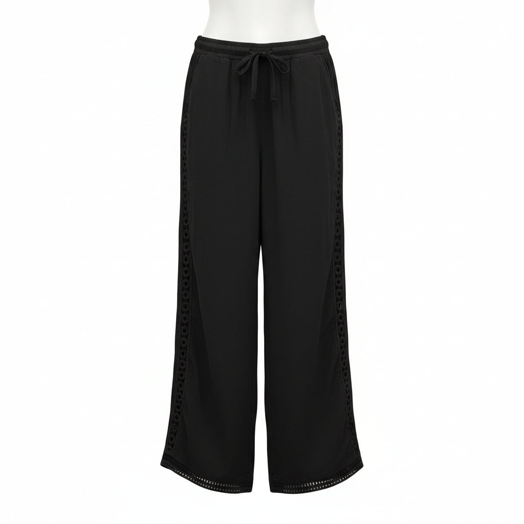 Person wearing black pants with side slits on a white background