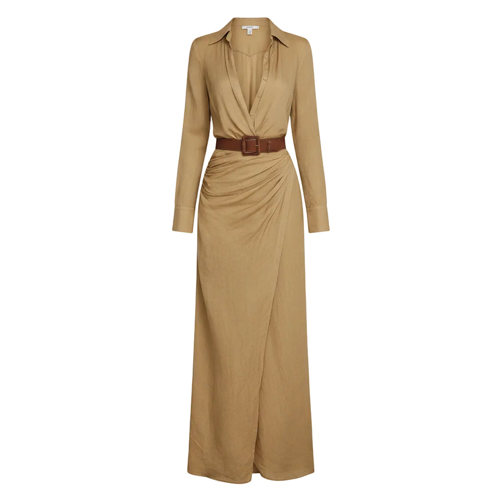 Woman wearing a long beige dress with a belt, holding a woven bag against a plain background.