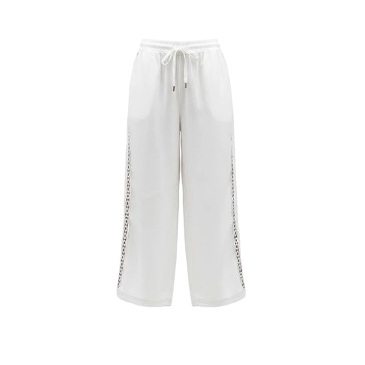 White pants with decorative trim worn by a person on a white background