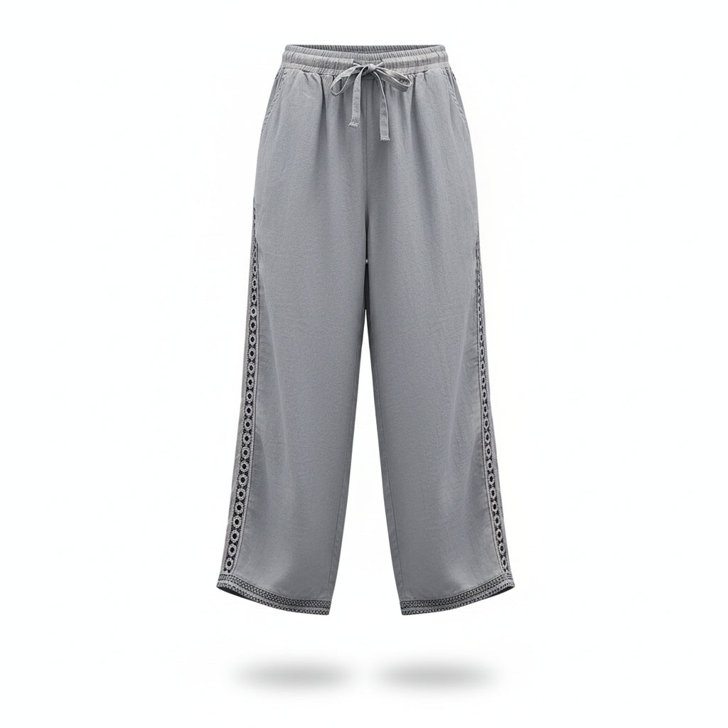 Light blue pants with decorative trim worn by a person on a white background
