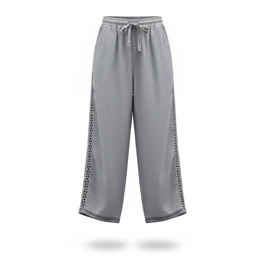 Light blue pants with decorative trim worn by a person on a white background